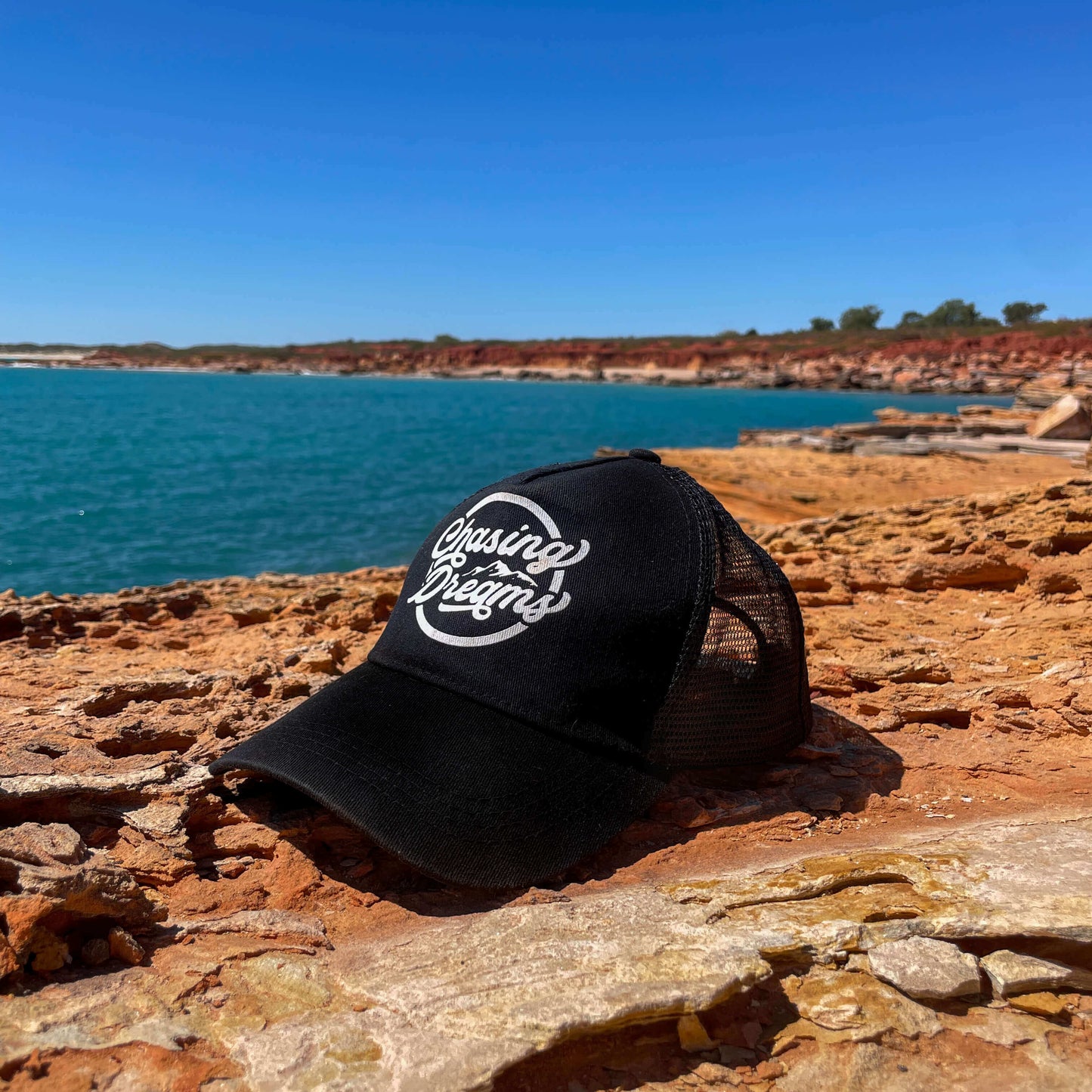 Chasing dreams black trucker cap with white logo